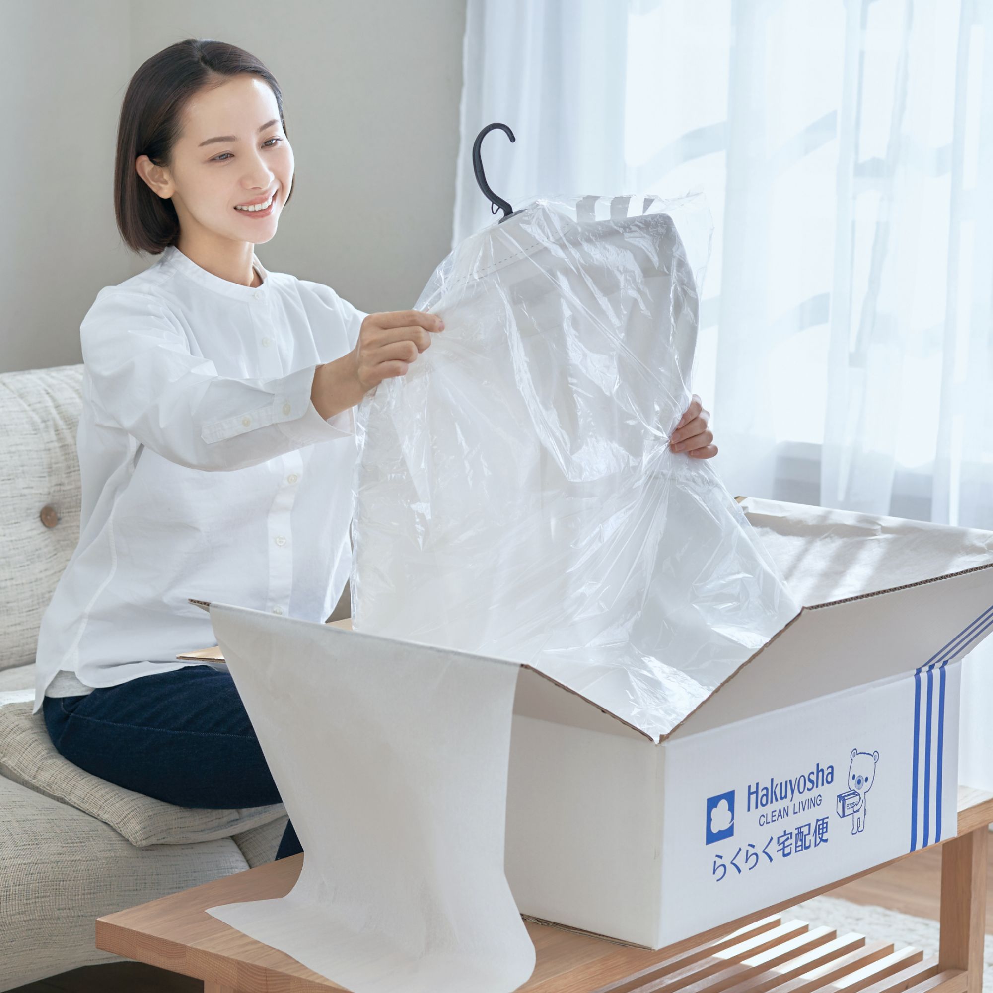宅配で届いた衣類を受け取る女性