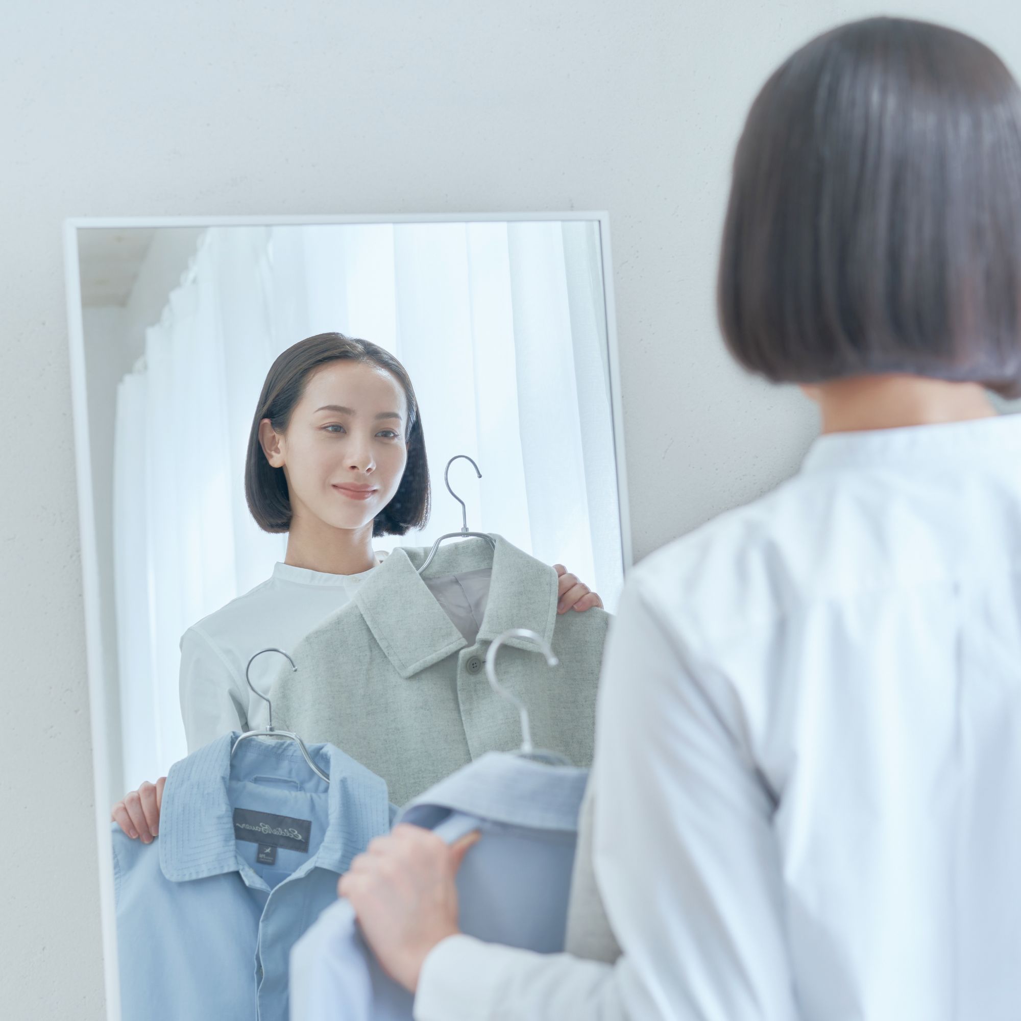 仕上がった衣類を確かめる女性