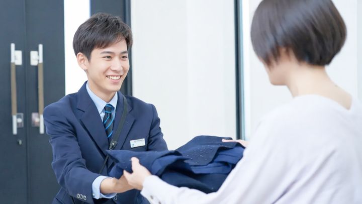 衣類を受け取る集配スタッフ